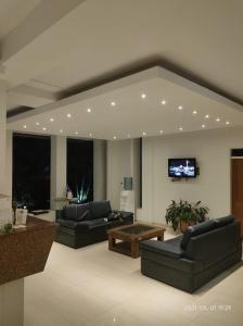 a living room with two couches and a tv at Hotel Luna Roja del Llano in Yopal