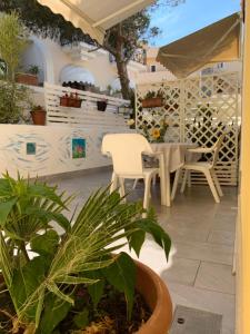 a patio with a table and chairs and plants at Bilocale “Cassiopea” vista Porto Nuovo in Lampedusa