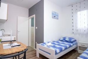 niewielka sypialnia z łóżkiem i stołem w obiekcie Ana ROOMS w mieście Ljubuški