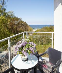 stół z wazą kwiatów na balkonie w obiekcie Porta Mare Apartments LuxView III w Dziwnówku