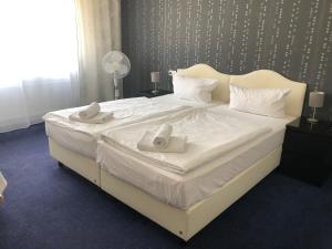 a large white bed with two towels on it at Hotel Royal Hanau in Hanau am Main +18 photos