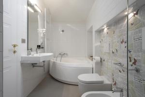 a white bathroom with a tub and a toilet and a sink at Santa Cesarea Residence Luxury Suite - La vetta del Sasso Barisano in Matera