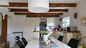 eine Küche mit einem Tisch und Stühlen in einer Küche in der Unterkunft Ferienwohnung-im-Speicher in Meldorf