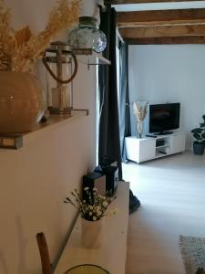 - un salon avec un vase sur une table et une télévision dans l'établissement Ferienwohnung-im-Speicher, à Meldorf