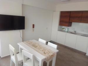a kitchen with a white table and white chairs at Depto Plaza Moreno in La Plata
