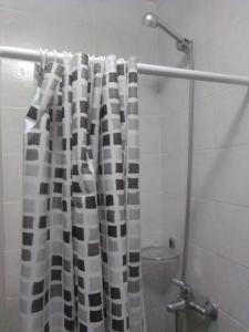a bathroom with a black and white shower curtain at Depto Plaza Moreno in La Plata