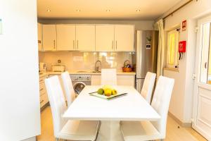 - une cuisine avec une table blanche et des chaises blanches dans l'établissement Resort Fazenda Viegas, à Lagos 33 autres photos