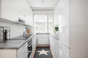 uma cozinha branca com um tapete estelar no chão em City Star em Jyväskylä