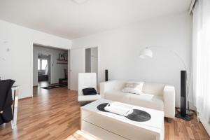 City Star في يوفاسكولا: غرفة معيشة مع أريكة بيضاء وطاولة