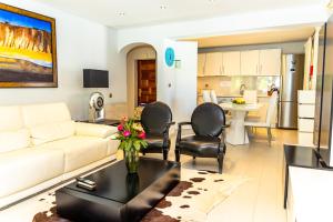 un salon avec un canapé et des chaises et une cuisine dans l'établissement Resort Fazenda Viegas, à Lagos