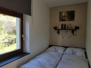 uma cama num quarto com uma janela em Ferienwohnung Wegespinne em Zwota