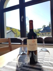 Eine Flasche Wein steht mit zwei Gläsern auf einem Tisch. in der Unterkunft Ferienwohnung Wegespinne in Zwota