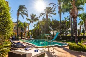 a pool with a slide and palm trees at Resort Fazenda Viegas in Lagos