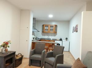 Una sala de estar con mesa y sillas y una cocina. en Casa de Ribes T1 Linda Vista, en Gerês 14 fotos más