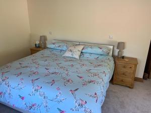 a bedroom with a bed with a blue comforter at Slerra Hill Bed and Breakfast, Clovelly in Bideford