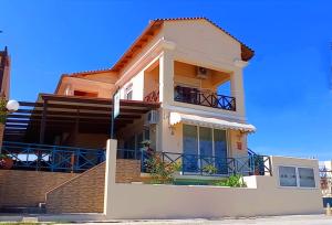 a house with a balcony and blue sky at Oceanides Apartments in Kourouta
