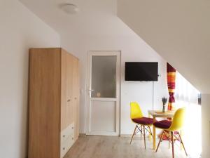 Habitación blanca con mesa y sillas amarillas en Lavender Apartments en Sînpetru