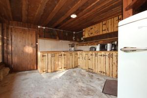 eine Küche mit Holzschränken und einem weißen Kühlschrank in der Unterkunft Abula puhkemaja 1 in Abula