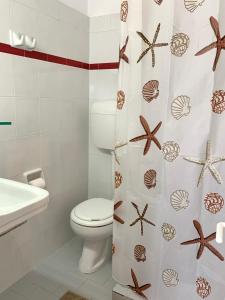 a bathroom with a toilet and a shower curtain with starfish at Mpiritis Mare in Lefkandi Chalkidas