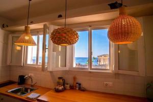 cocina con 2 luces colgantes y vistas al océano en ROMANTIC HOUSE 6 STEPS FROM THE SEA, en Mókhlos