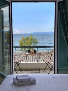 uma vista para o oceano a partir de uma varanda com uma mesa em Mpiritis Mare em Cálcis