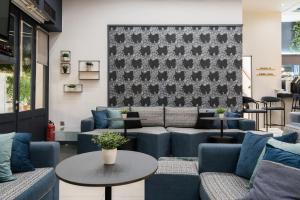 a waiting room with blue couches and a table at Klimis Hotel in Spetses