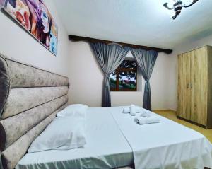 a bedroom with a bed with towels on it at Vila Emilio in Udënisht