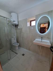 a bathroom with a sink and a shower and a mirror at Vila Emilio in Udënisht +32 photos