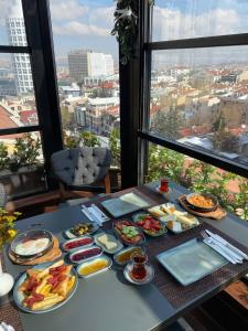 une table avec des assiettes de nourriture sur une table avec une fenêtre dans l'établissement The Life Hotel & Spa, à Yenimahalle