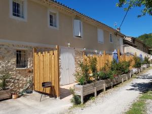 a house with a wooden fence and some plants at Les gîtes de Moussan in Montbrun-les-Bains