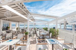 an outdoor patio with tables and chairs and the ocean at Klimis Hotel in Spetses