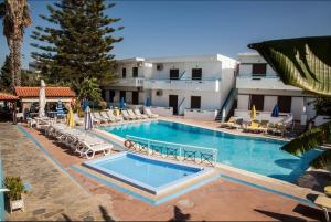 a large swimming pool with lounge chairs and a building at Kosinmyheart Apartment 11 & Studio10 in Kos