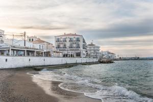 a view of a beach with buildings and the water at Klimis Hotel in Spetses
