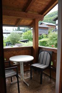 a porch with a table and two chairs and a table at Haus Klaushofer in Fuschl am See
