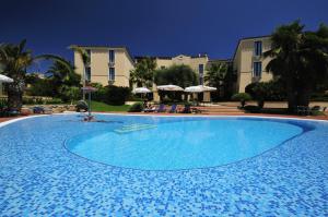 a large blue swimming pool in front of a building at Hotel Arbatasar in Àrbatax