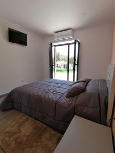 ein Schlafzimmer mit einem Bett, einem Sofa und einem Fenster in der Unterkunft Alojamentos Martinho in Quintas