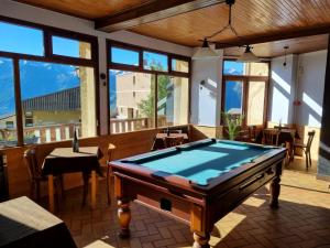 a pool table in a room with windows at Hotel Le Beau Site in Auris