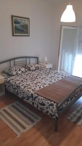 a bed in a bedroom with a blanket on it at Apartmani Darko in Kornić