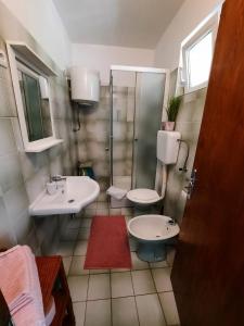 a bathroom with two sinks and a shower at Apartmani Darko in Kornić