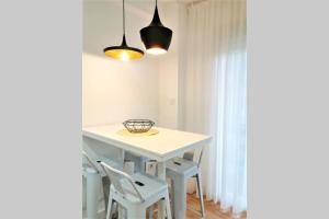un tavolo bianco con sedie in una stanza con finestra di Acogedor Estudio Pontevedra Centro a Pontevedra