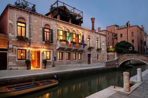 un bâtiment situé à côté d'un canal dans une ville dans l'établissement Palazzetto Madonna, à Venise