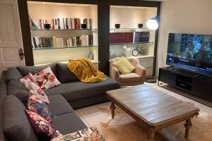 uma sala de estar com um sofá e uma televisão de ecrã plano em Le petit haut de Meuse em Profondeville