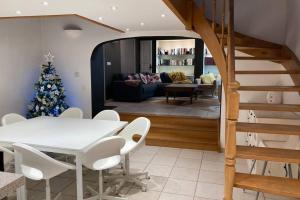 a dining room and living room with a christmas tree at Le petit haut de Meuse in Profondeville