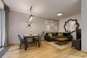 uma sala de estar com uma mesa e um sofá em Zentrum II Apartament IMPERO z Parkingiem em Poznań