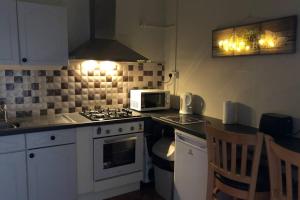 a kitchen with a stove top oven next to a microwave at Canal View in Belmullet