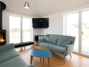 een woonkamer met een bank en een open haard bij 10 person holiday home in Brovst in Tranum Strand