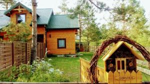 a log cabin with a wreath on the front of a house at Domek apartament w Puszczy Augustowskiej in Płaska
