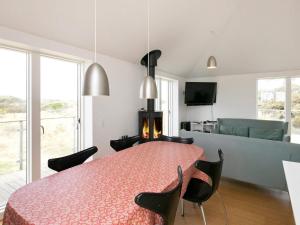 een kamer met een tafel en stoelen en een woonkamer bij 10 person holiday home in Brovst in Tranum Strand