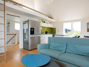 een woonkamer met een blauwe bank en een keuken bij 10 person holiday home in Brovst in Tranum Strand
