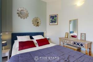 a bedroom with a bed with red pillows and a mirror at Villa Capriciosa - Five Stars Holiday House in Beaulieu-sur-Mer
